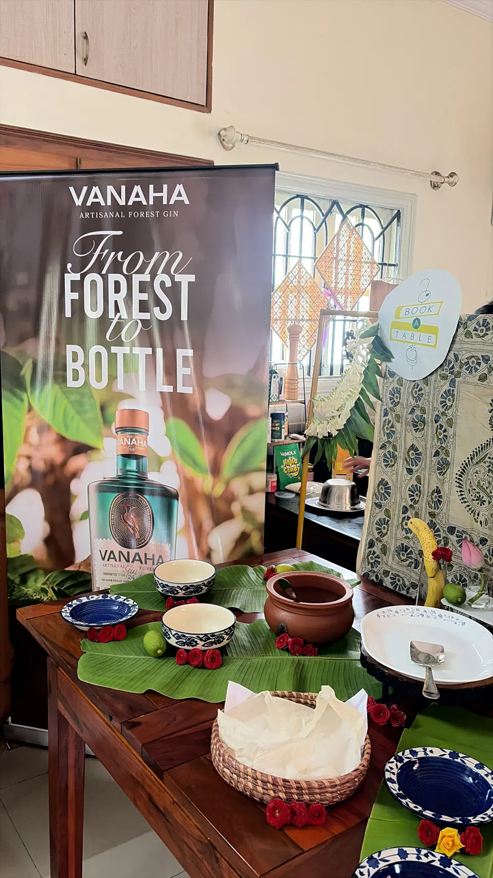 Vanaha Artisanal Forest Gin "From Forest to Bottle" banner beside the banana-leaf buffet