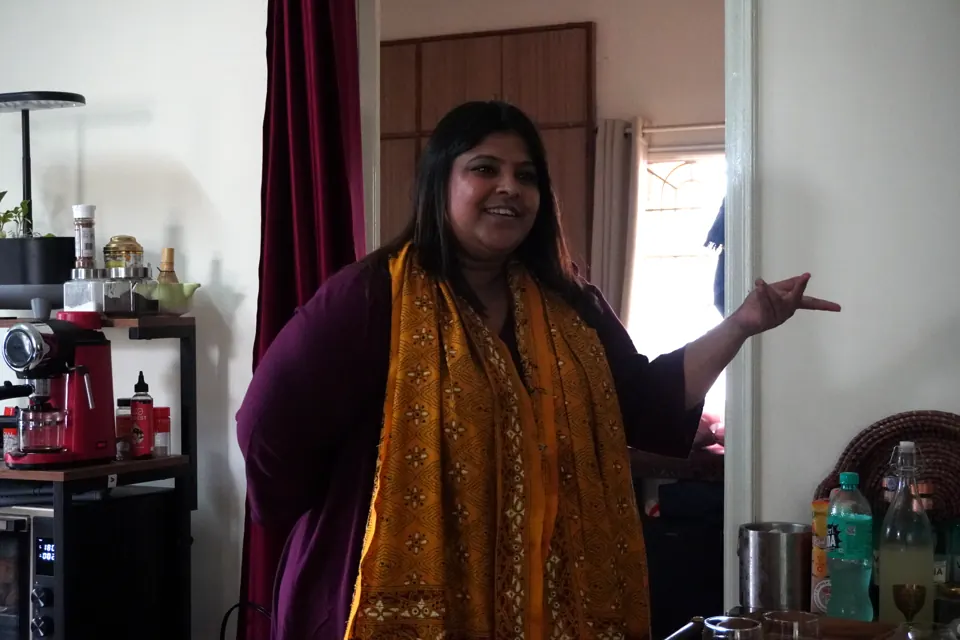 Kriti in a mustard dupatta gestures while leading the book discussion in the living room